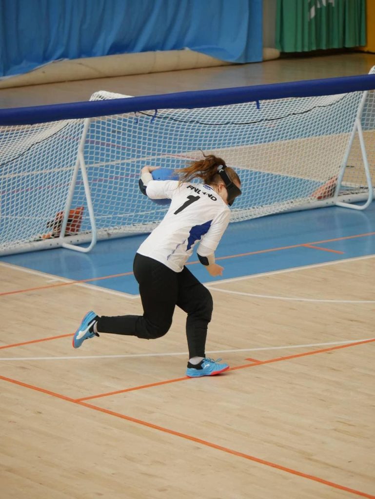 Kuvassa valkoisessa pelipaidassa pelinumerolla 7 Miina Grönroos heittämässä maalipalloa.